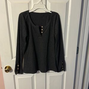 Grey top. Button accent on sleeves and neck.